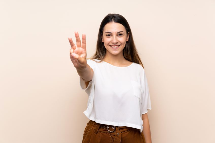 young brunette woman over isolated background happy and counting three with fingers